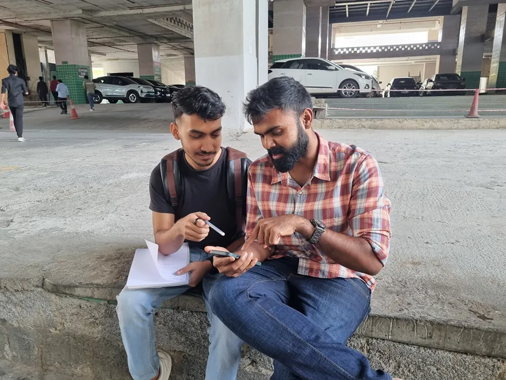 Two of the team running an interview outside, taking notes on paper.